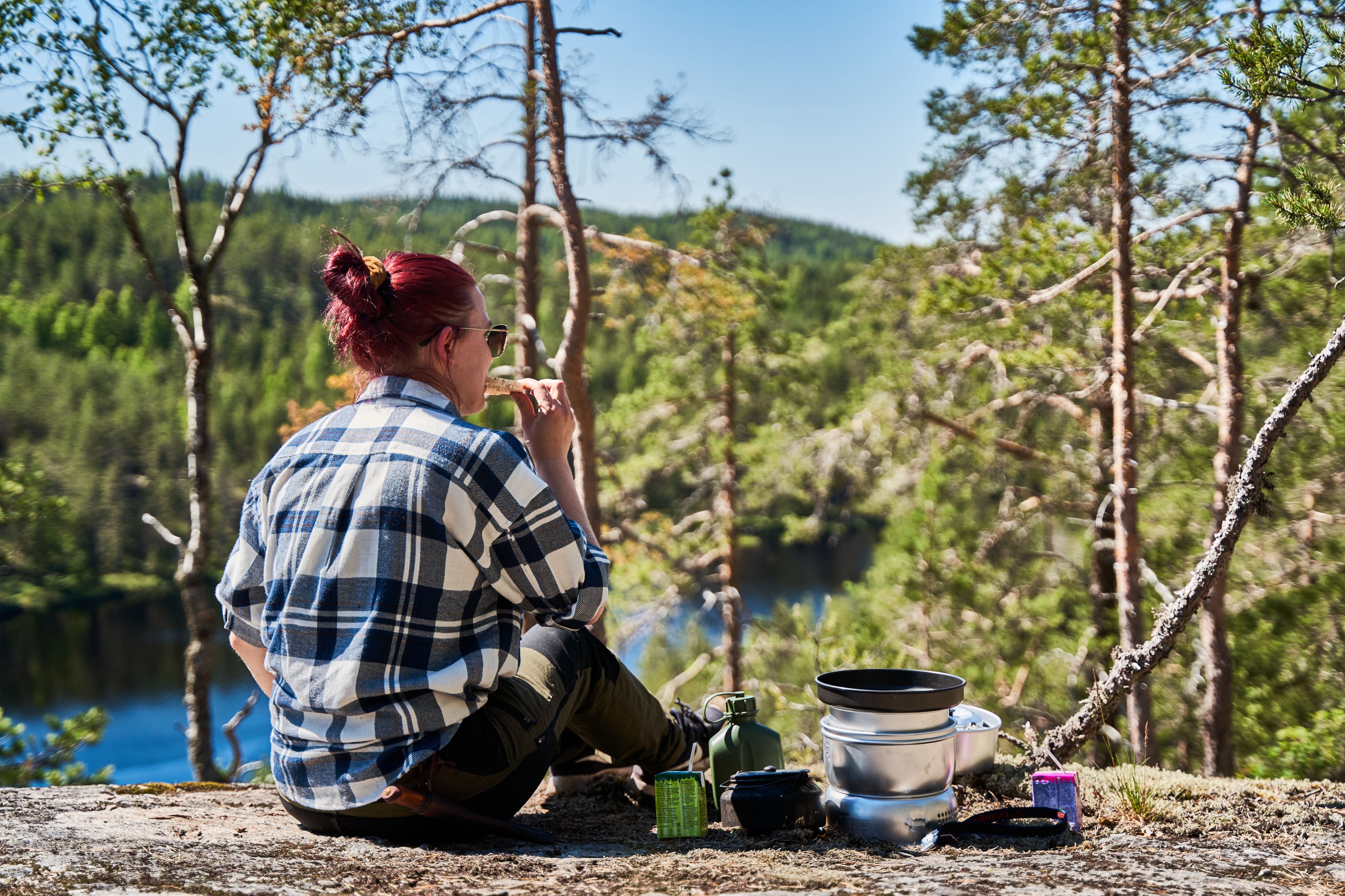 Retkeilijä syö eväitä kalliolla